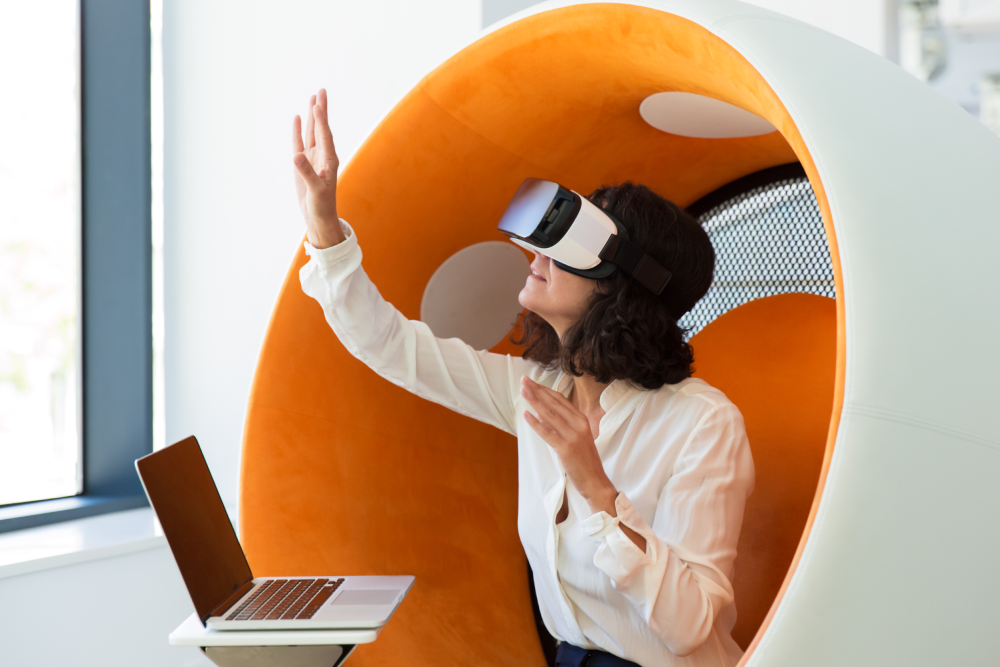 Mulher de negócios sentada, utilizando simulador de Realidade Virtual, uma tendência em eventos